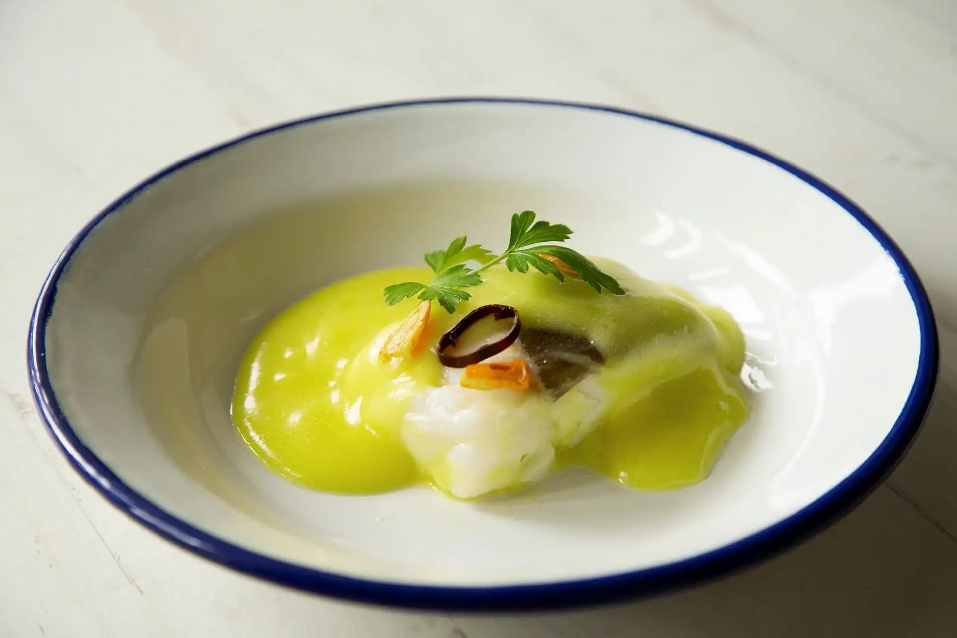 Receta de Bacalao al pil pil con aguacate y atún: receta magistral y saludable preparada paso a paso — fotografía editorial de RecetaGenial