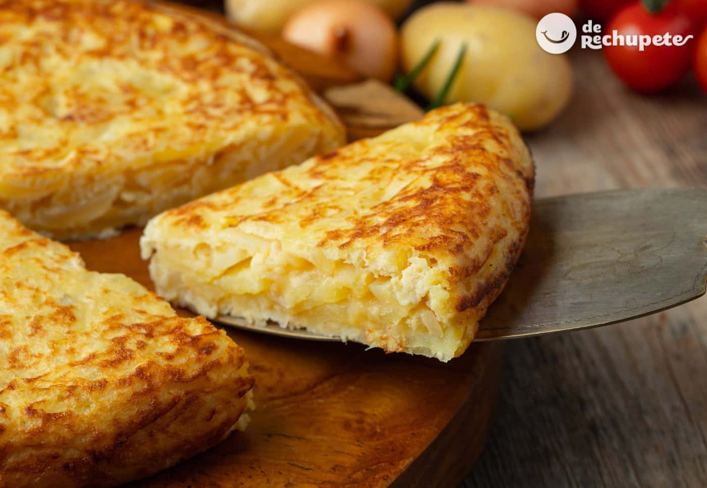Una deliciosa tortilla española jugosa con cebolla recién hecha, cortada en porciones, mostrando un interior cremoso y patatas perfectamente confitadas sobre un plato de cerámica rústica.